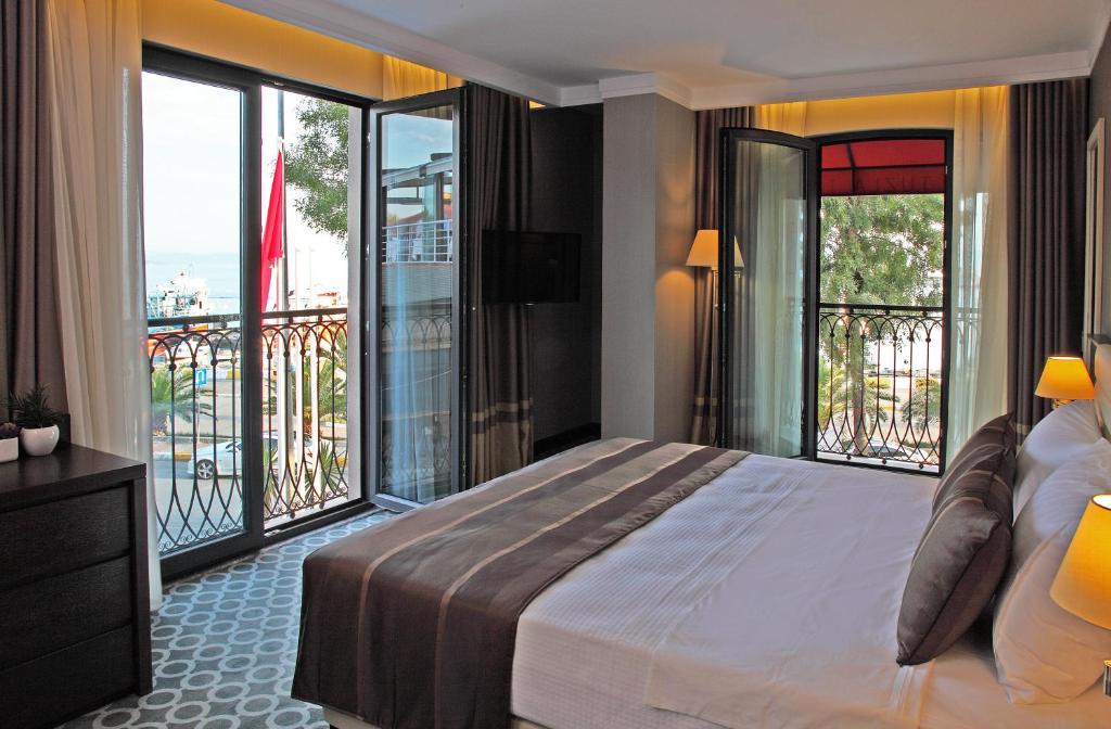 a bedroom with a large bed and a balcony at Tuzla Town Hotel in Tuzla