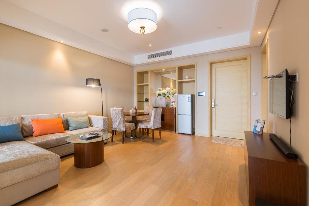 ein Wohnzimmer mit einer Couch und einem Tisch in der Unterkunft Pinxiayuan Apartment in Lvcheng Resort in Zhoushan