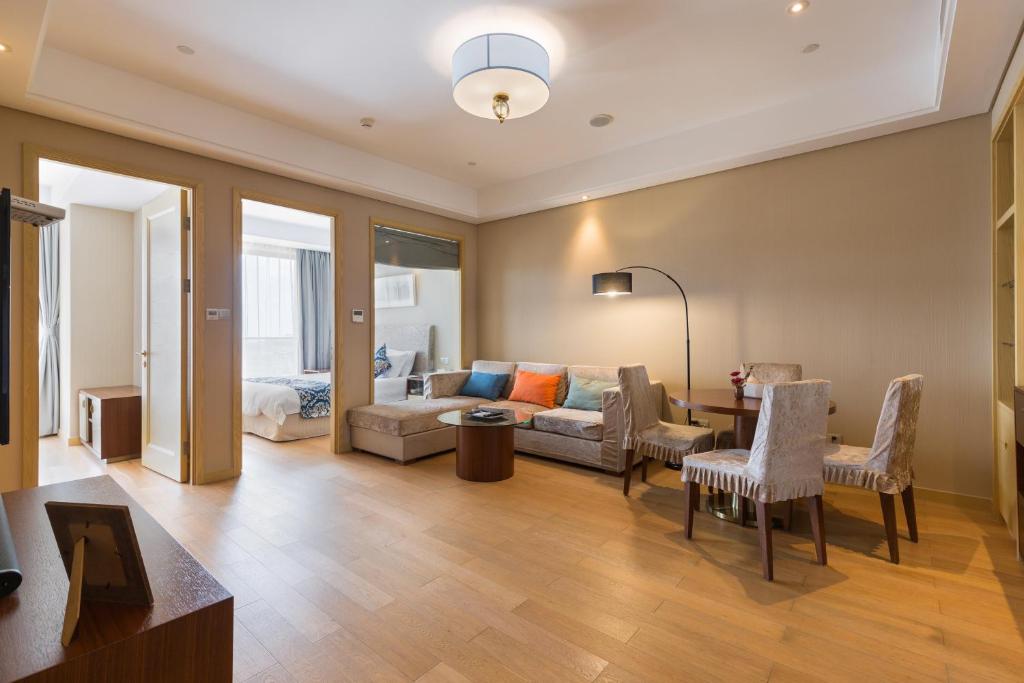 ein Wohnzimmer mit einer Couch und einem Tisch in der Unterkunft Pinxiayuan Apartment in Lvcheng Resort in Zhoushan