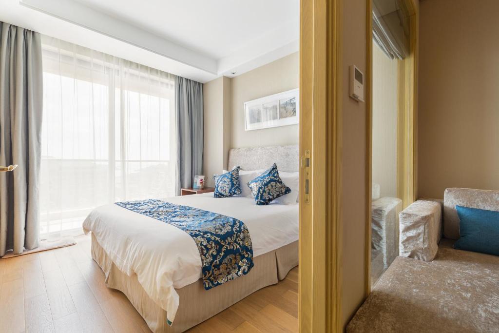 ein Hotelzimmer mit einem Bett und einem Fenster in der Unterkunft Pinxiayuan Apartment in Lvcheng Resort in Zhoushan