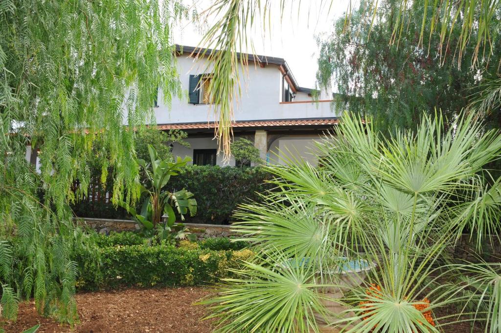uma casa com palmeiras em frente em Villa Grazia em Noto Marina