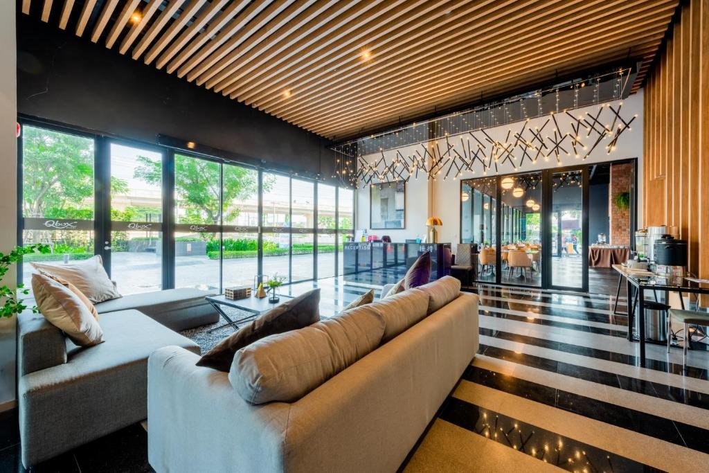 A spacious lobby lounge with multiple sofas, full-height windows and a glossy marble-look floor.