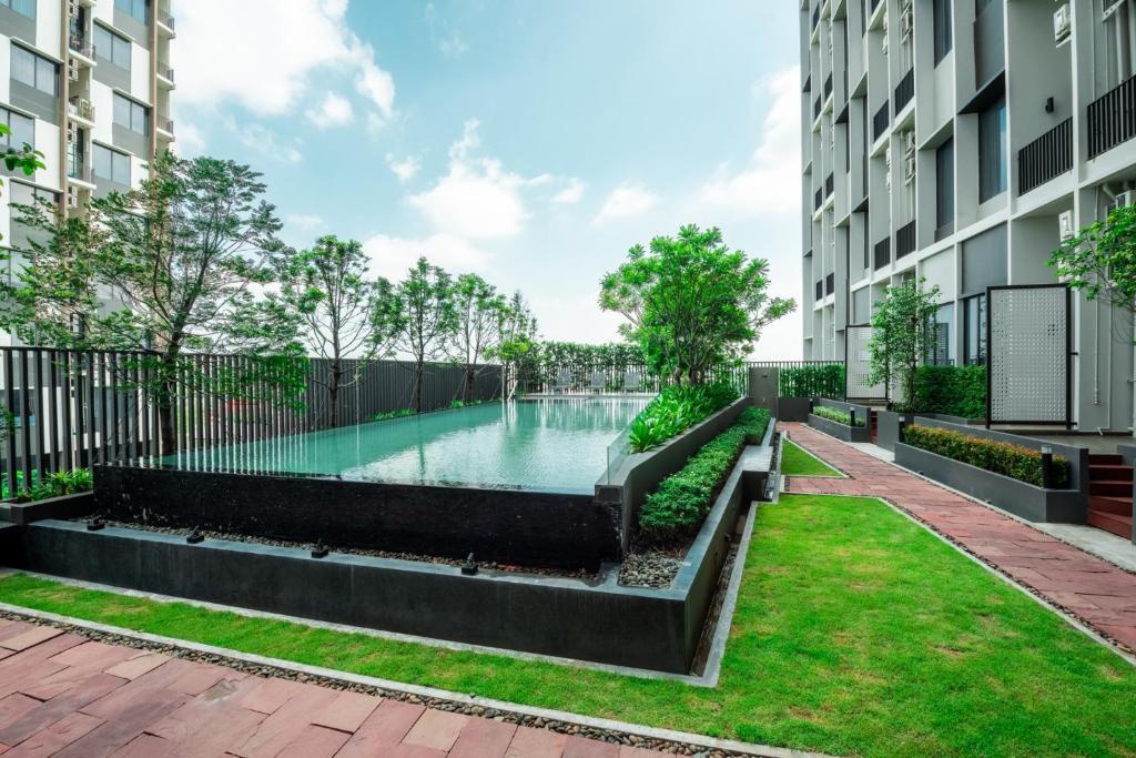 A narrow outdoor pool runs through a landscaped courtyard between hotel buildings.