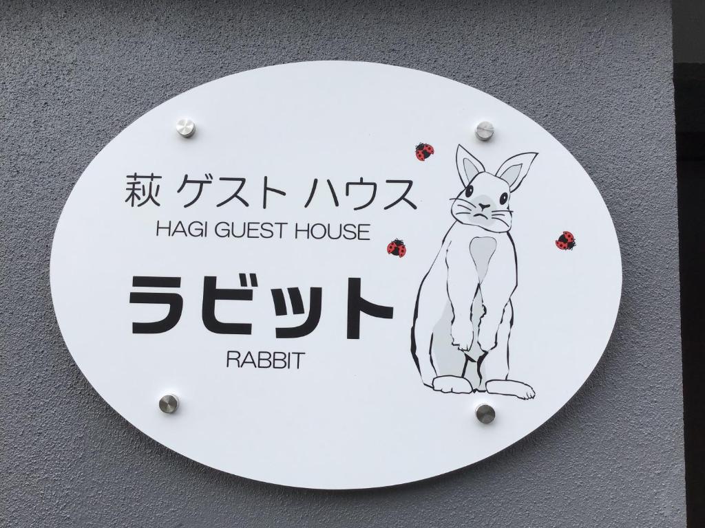 a sign with a picture of a cat on a wall at 萩ゲストハウスラビット in Hagi