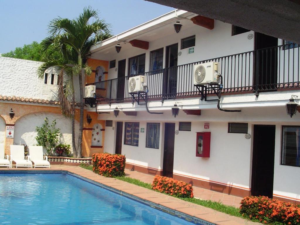 un hotel con piscina frente a un edificio en Hotel & Suites Coral , en Puerto Vallarta