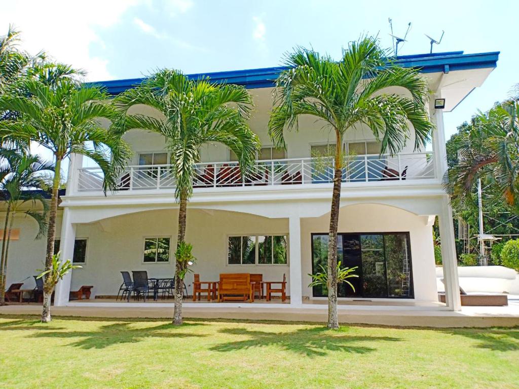 a house with palm trees in front of it at Luxury Villa with Pool in Tropical Garden in Puerto Princesa City