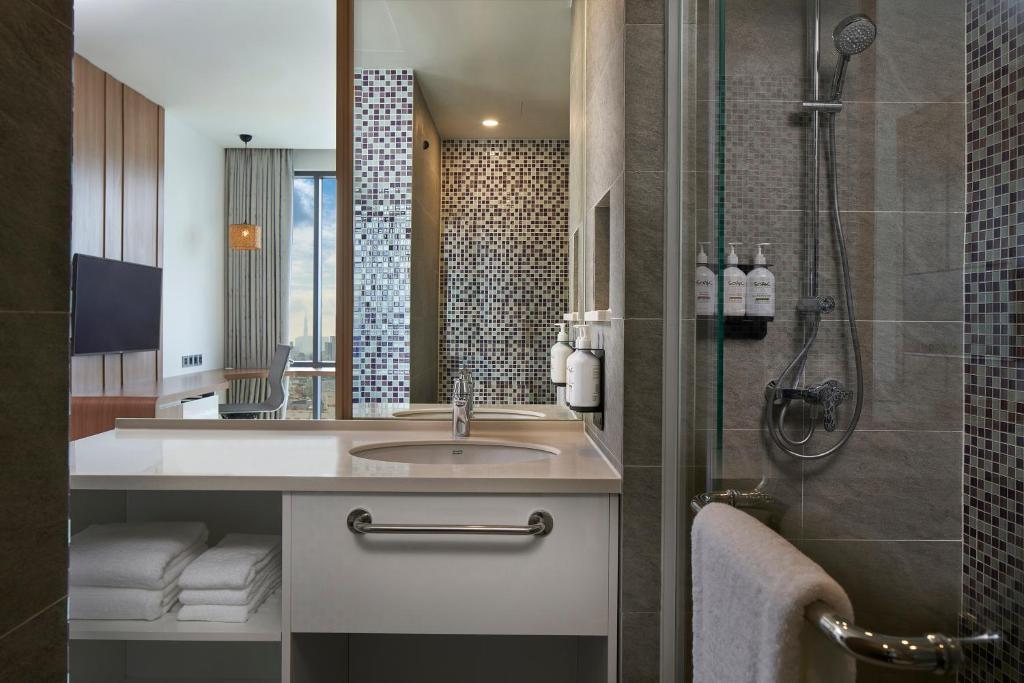 a bathroom with a sink and a shower at Holiday Inn & Suites Saigon Airport by IHG in Ho Chi Minh City