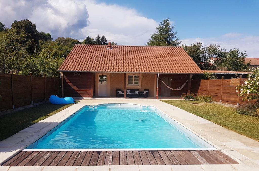 - une piscine en face d'une maison dans l'établissement Dépendance au goût de vacances, à Moulainville-la-Basse