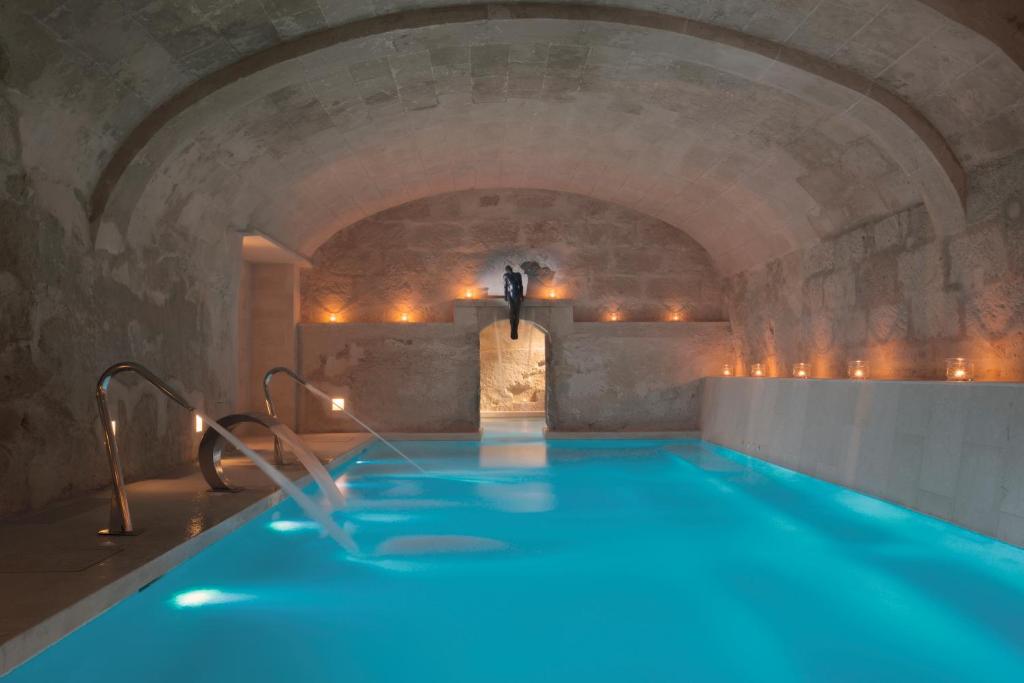 een groot binnenzwembad in een grot met een tunnel bij Jardí de Ses Bruixes Boutique Hotel in Mahón