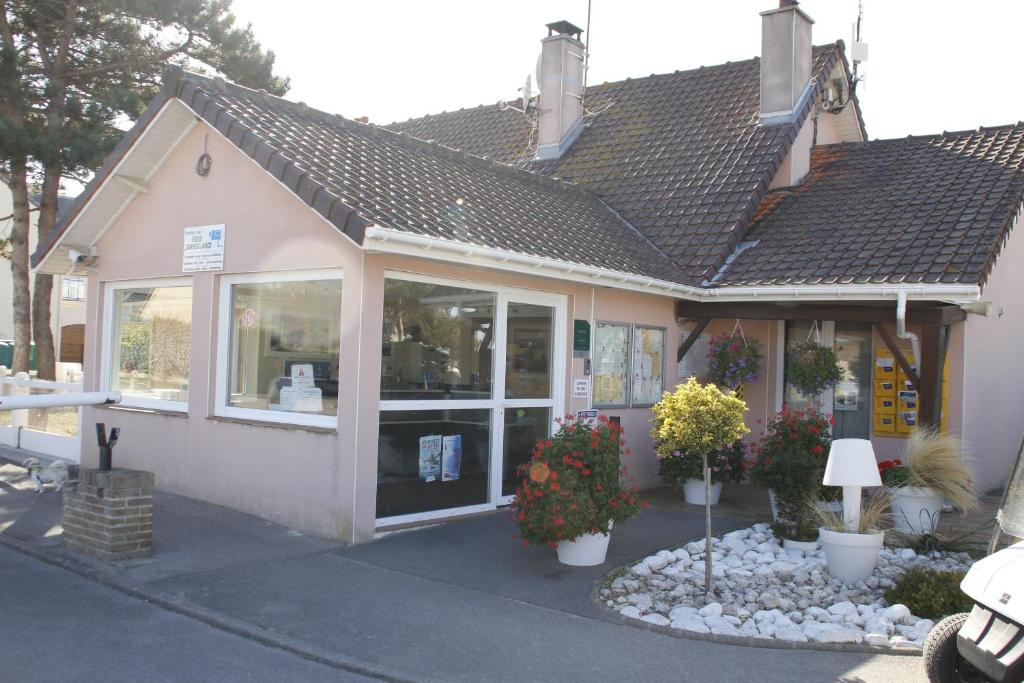 a store front with flowers in front of it at Camping de la Mer in Camiers