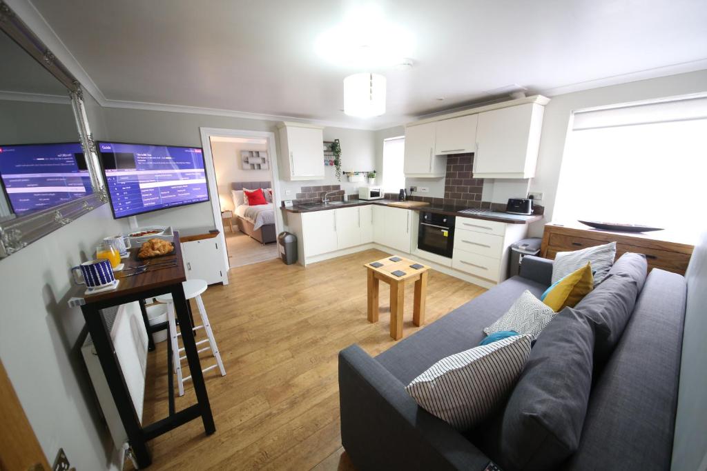 ein Wohnzimmer mit einem Sofa und einer Küche in der Unterkunft Number 4 in Exeter