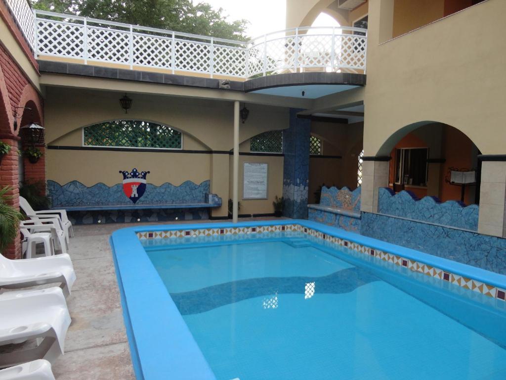 a swimming pool with a pool table and chairs at Hotel Posada del Rey in San Blas