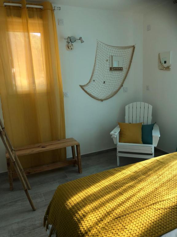 a bedroom with a bed and a chair and a window at Maxima Sunset in Sainte-Maxime