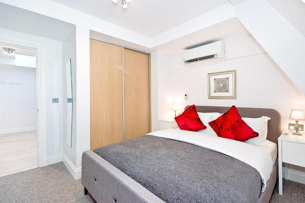 a bedroom with a large bed with red pillows at Eldon Chambers Flat 2 by City Living London in London