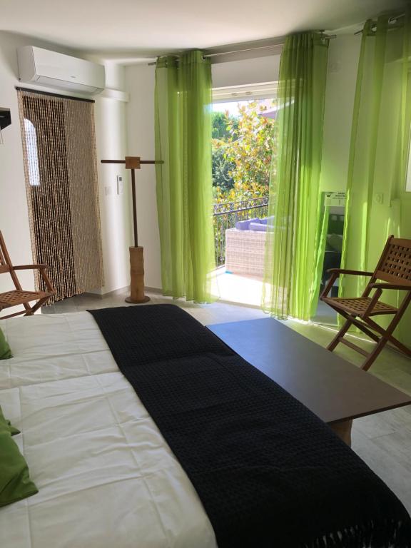 a bedroom with a large bed with green curtains at Maxima Sunset in Sainte-Maxime