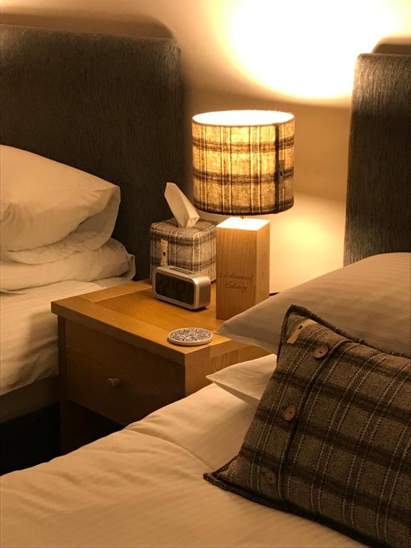 a hotel room with two beds and a lamp at Ardconnel Bed and Breakfast in Kirkwall