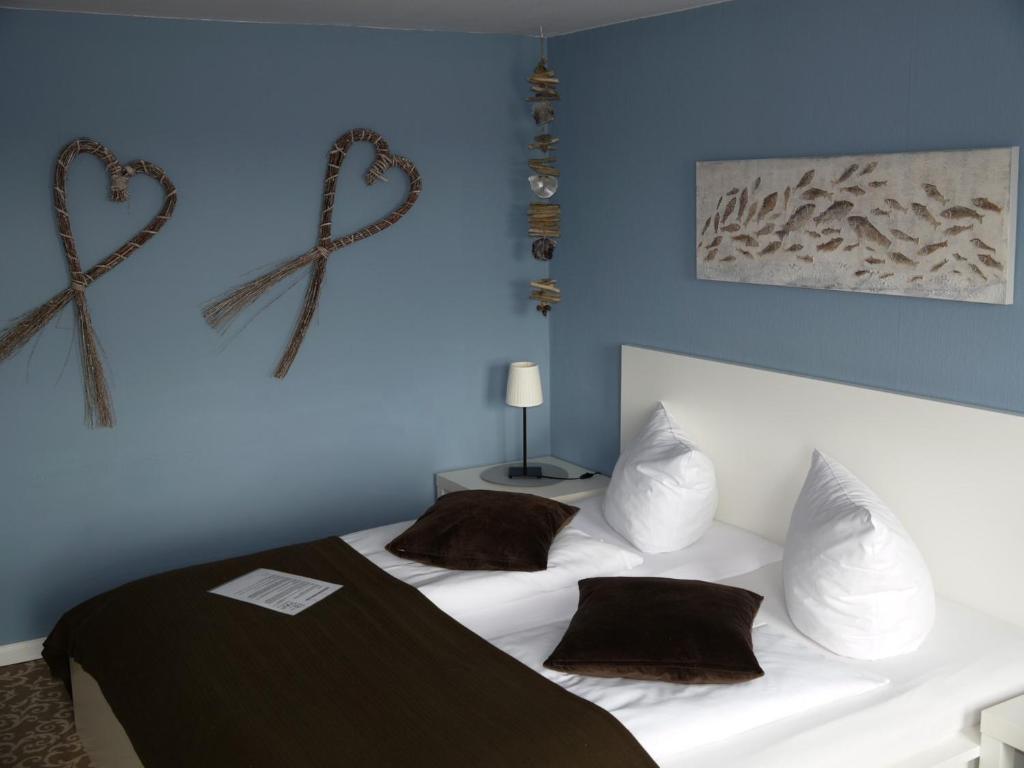 a bedroom with a white bed with two hearts on the wall at Gästehaus Von Herzen in Lauenburg