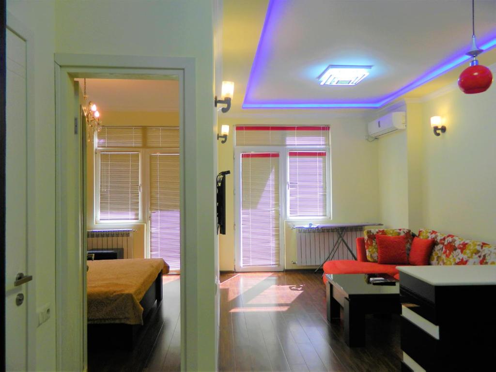 a living room with a blue light on the ceiling at Chemi Saxli Apartment in Batumi