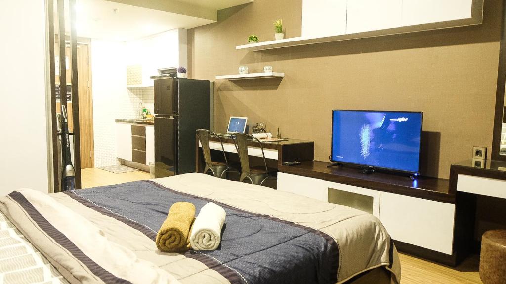 a bedroom with a bed and a tv on a desk at Galeri Ciumbuleuit 3 by AYA Stays in Bandung