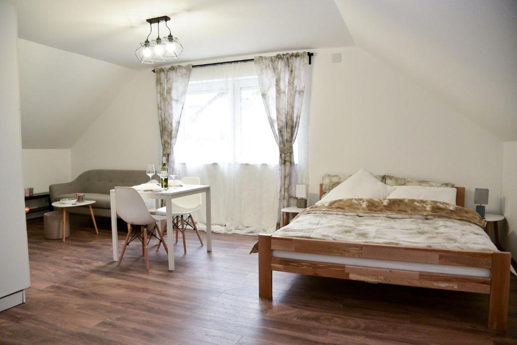 Schlafzimmer mit einem Bett, einem Tisch und einem Fenster in der Unterkunft Tesla Coil Apartments in Gospić