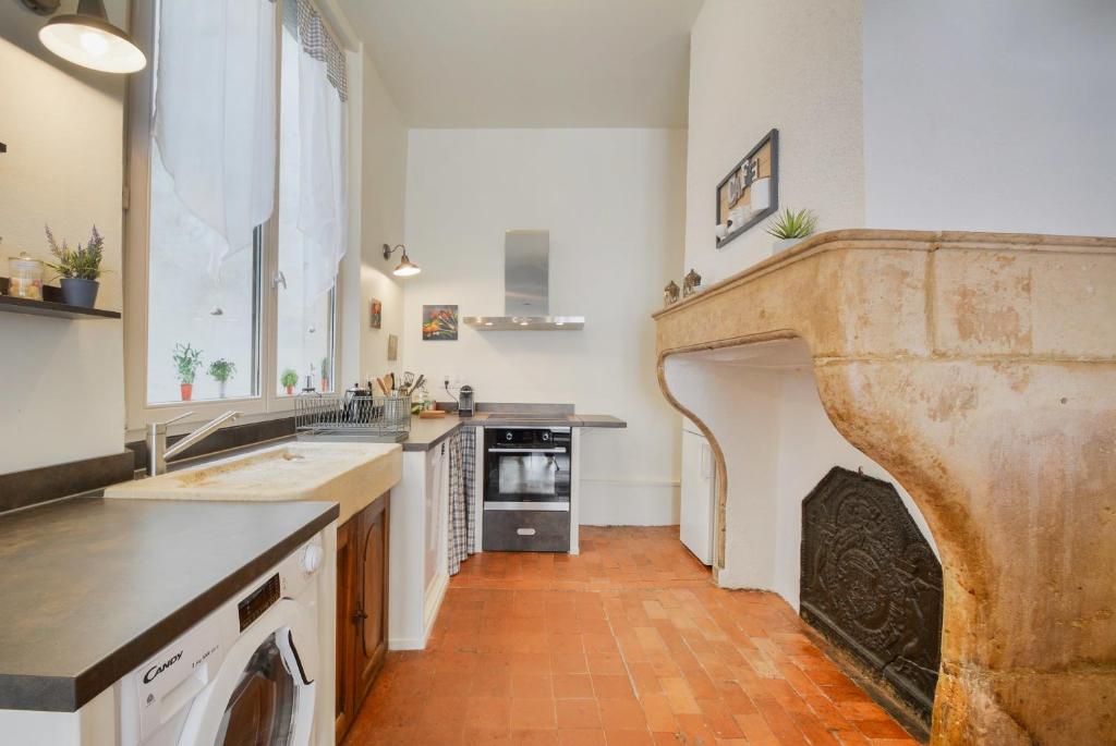 a large kitchen with a fireplace in the middle at Le cocon des Deux Sirènes in Nancy
