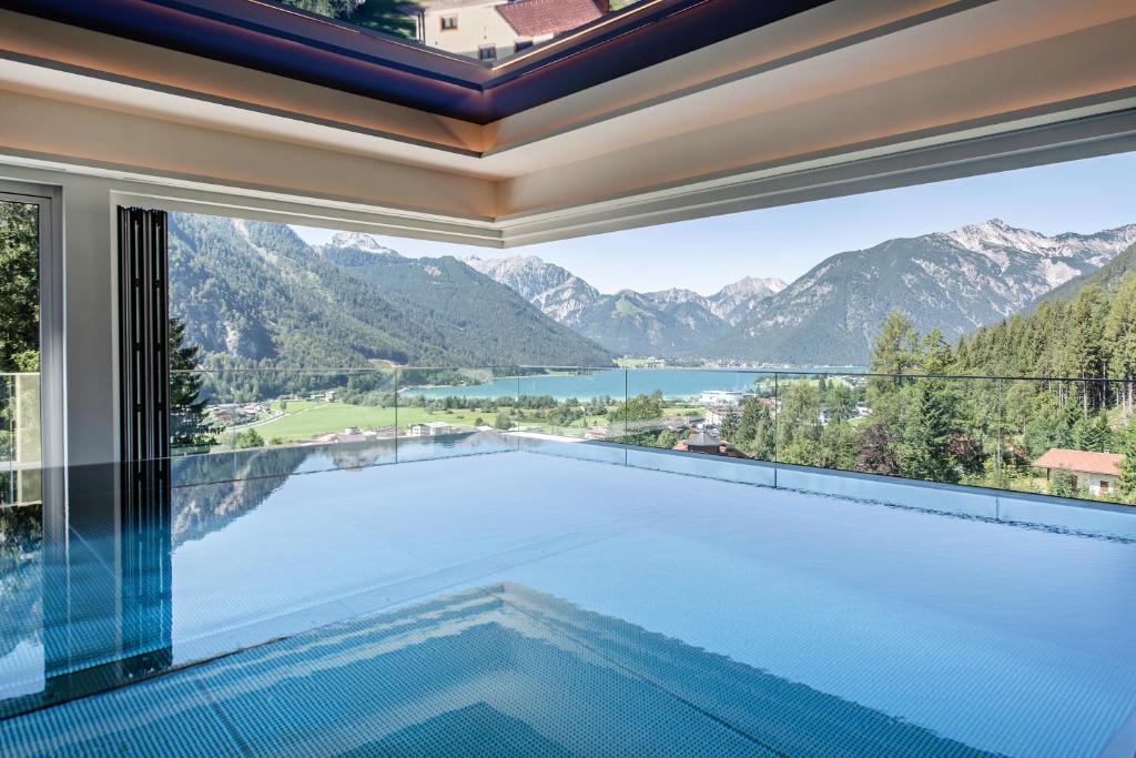 a swimming pool in a house with a view of the mountains at Naturhotel Alpenblick in Maurach