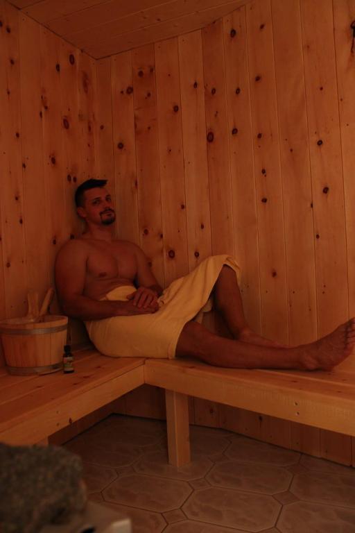 a man is sitting in a sauna at Alpengasthof zur Post in Schattwald