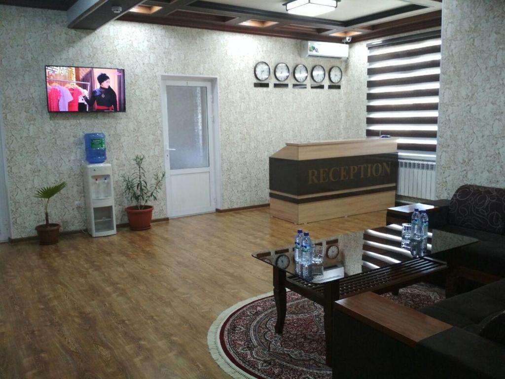 una sala de recepción con sofá y mesa en hostel Farovon, en Margilan