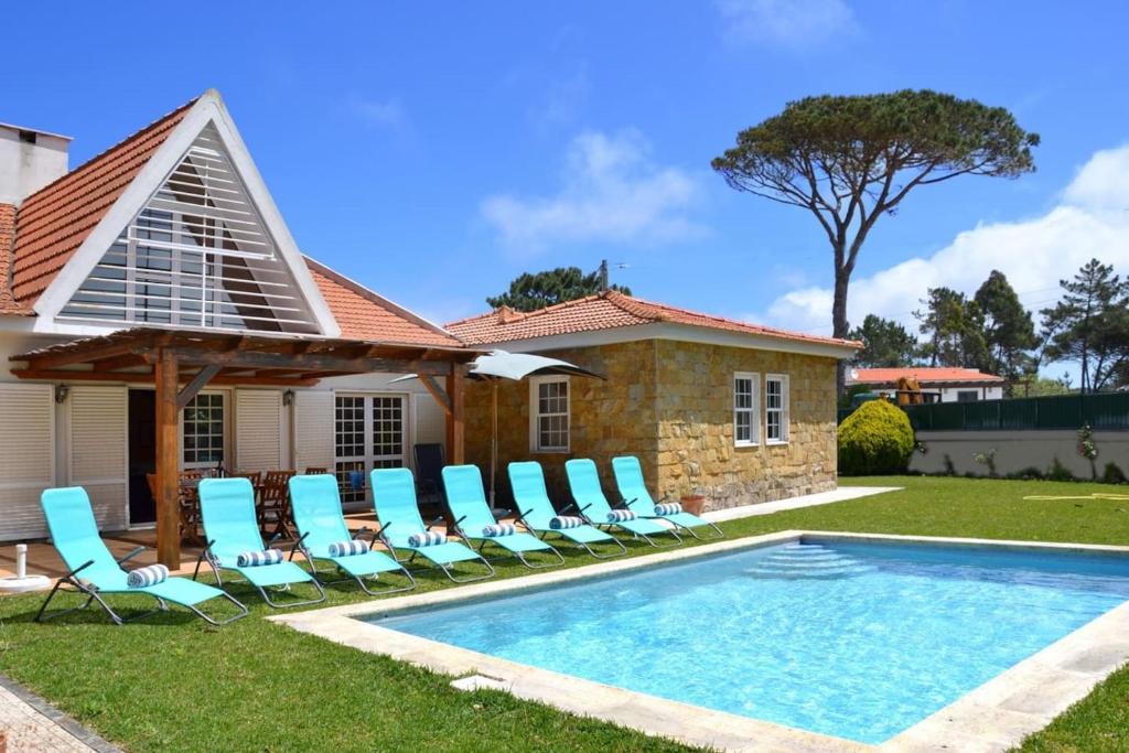 une maison avec une piscine et des chaises longues dans l'établissement Villa Mara, à Sintra