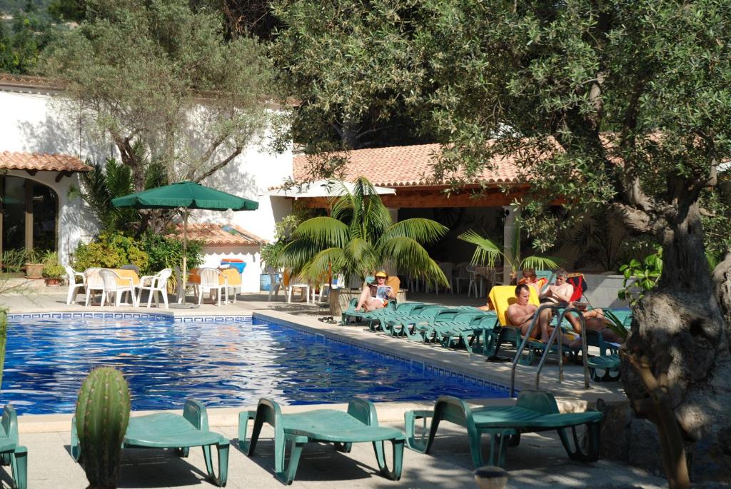 un grupo de personas sentadas alrededor de una piscina en Soller Garden en Port de Soller