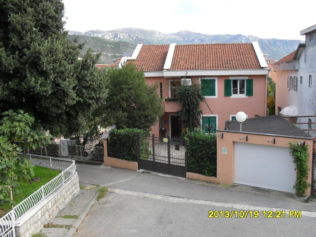 une maison avec une clôture et un garage dans l'établissement Apartments Three Star, à Budva