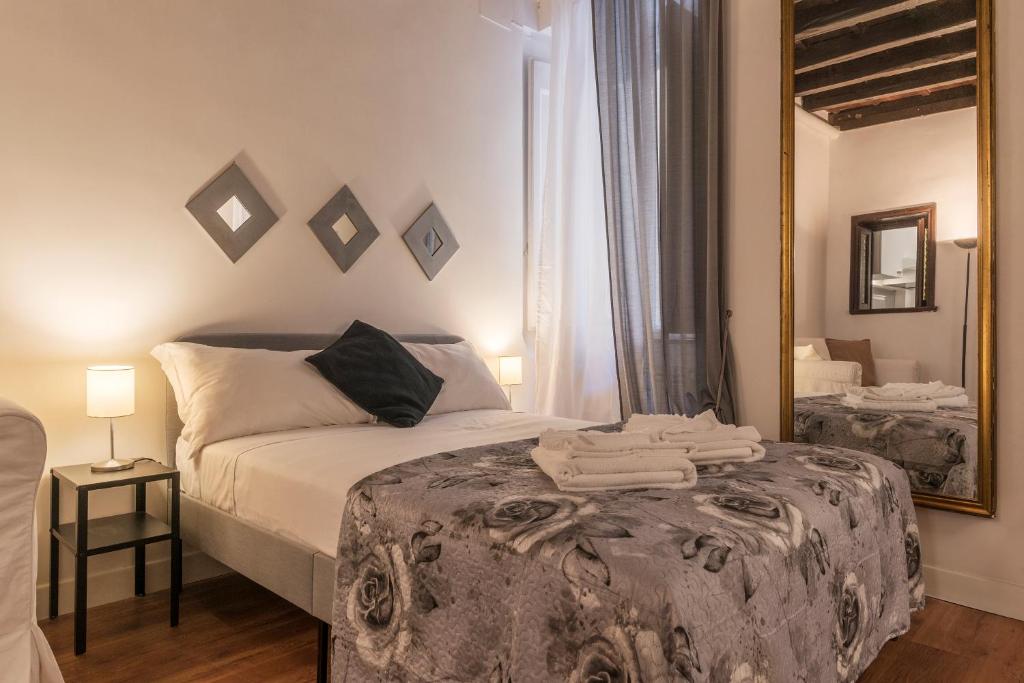 ein Schlafzimmer mit einem Bett und einem großen Spiegel in der Unterkunft Fori Imperiali Elegant Apartment in Rom