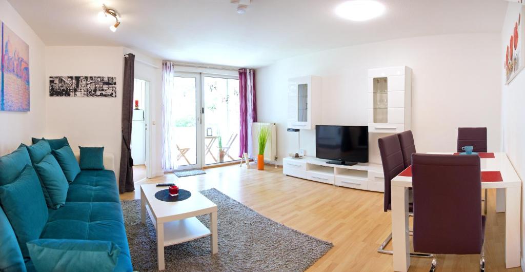 a living room with a blue couch and a tv at Ferienwohnung Rodenhof in Saarbrücken