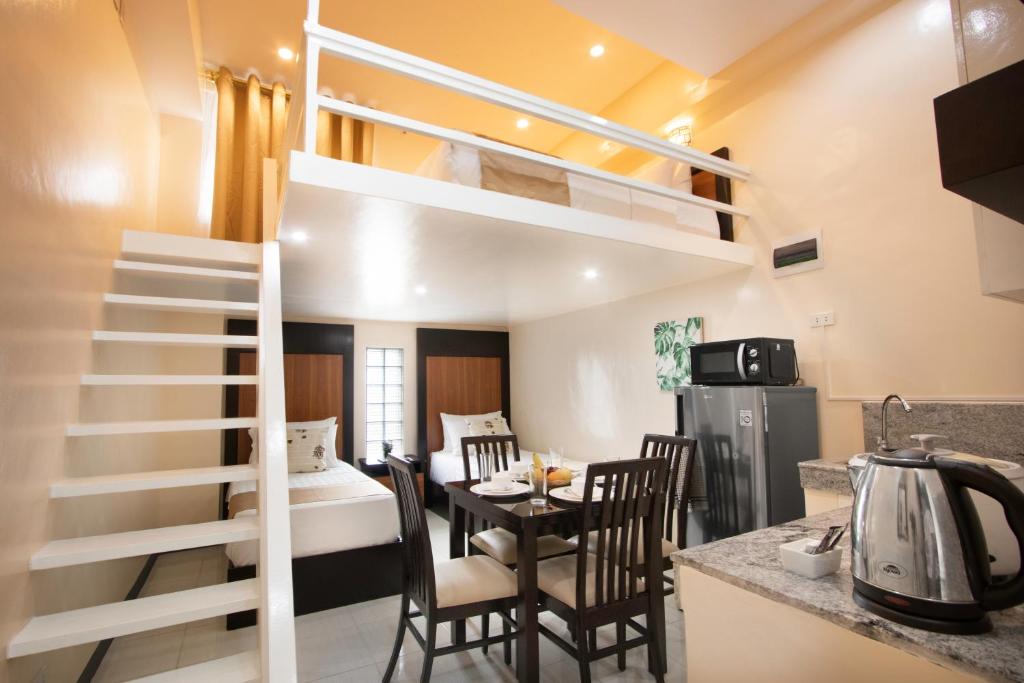 um quarto com uma cama alta e uma sala de jantar em Rosetta Guest House em Ormoc