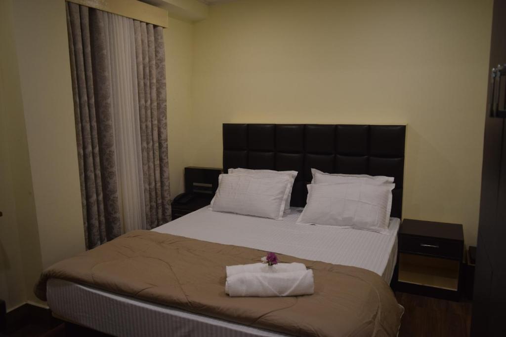 a bedroom with a large bed with two towels on it at Denzong Khim in Gangtok