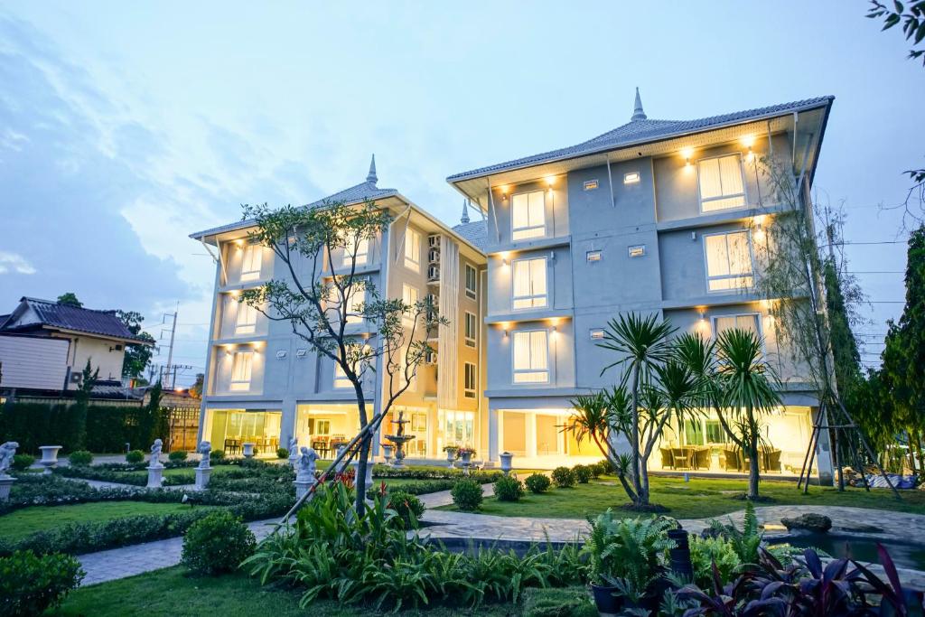 a large building with a garden in front of it at Nantra Chiangmai Riverfront Hotel in Chiang Mai