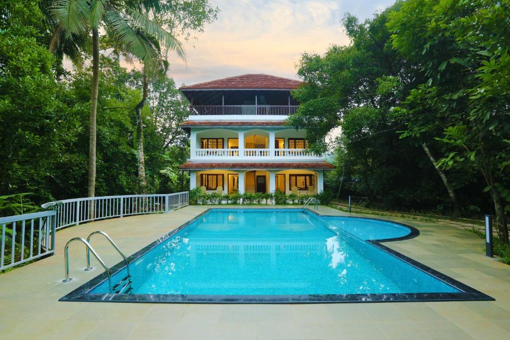 a house with a swimming pool in front of a house at Once Upon The River, Aluva - Near Cochin International Airport in Cochin