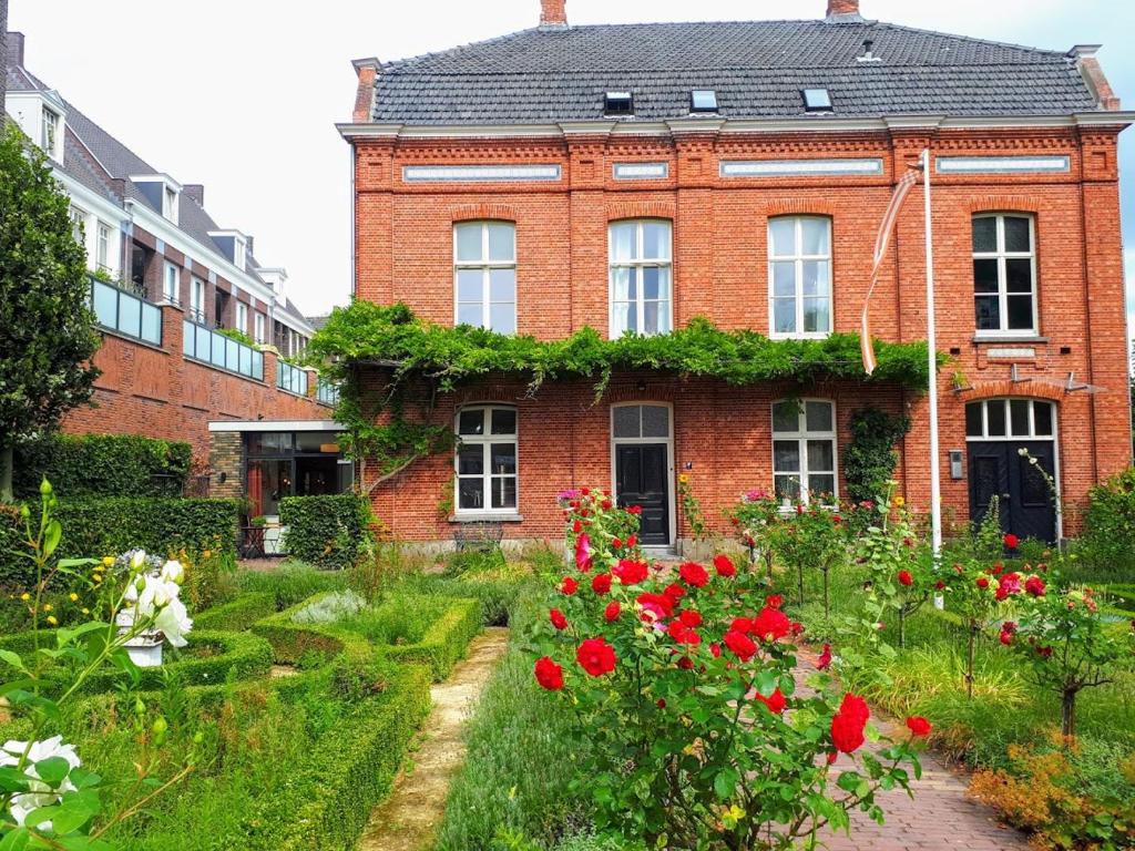 une maison en briques avec un jardin en face de celle-ci dans l'établissement Het Gindrahuis, à Bladel