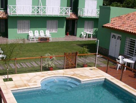 a swimming pool in front of a house at Complejo Hueney Departamentos in Mar de Ajó