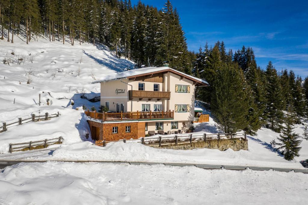 ein Haus auf einem schneebedeckten Hügel mit Bäumen in der Unterkunft Ferienhaus Olpererblick in Tux
