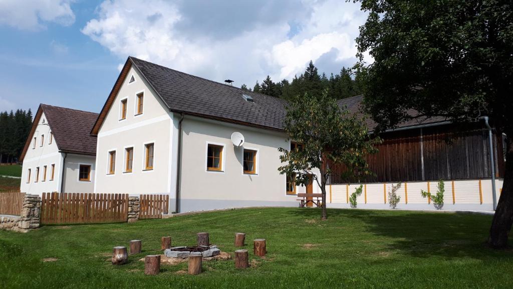 ein großes weißes Haus mit einem Zaun und einem Hof in der Unterkunft Ferienhaus Buxbaum in Arbesbach