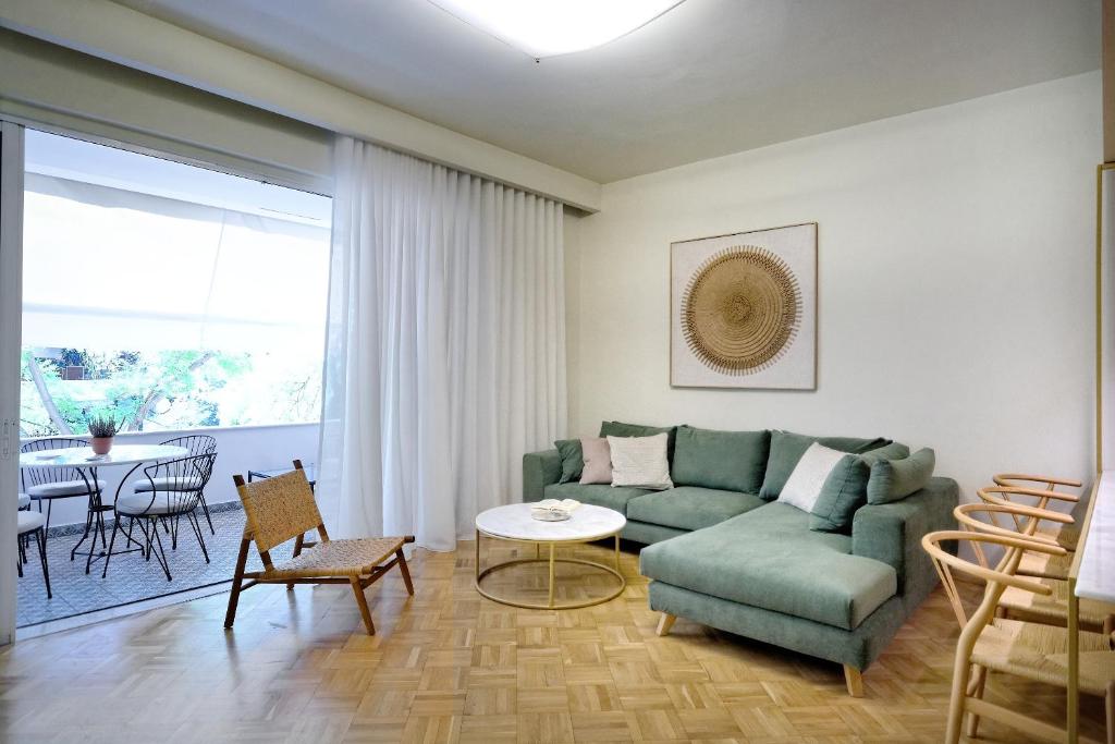 - un salon avec un canapé vert et une table dans l'établissement The Fancy Philosopher Apartment, à Athènes