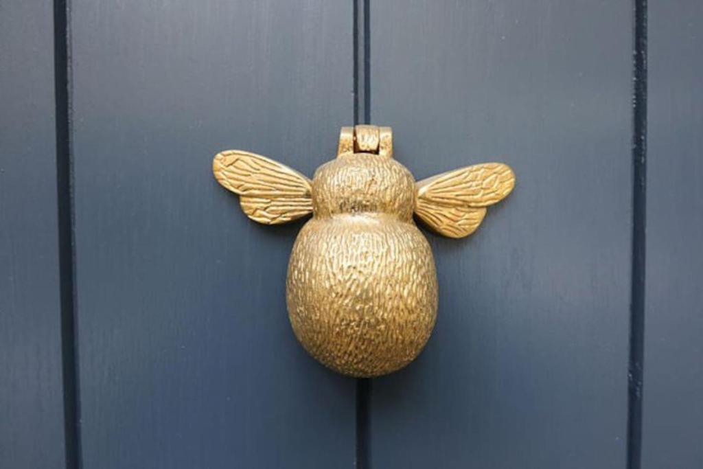 a gold vase is hanging on a door at The House on the Hill in Frome