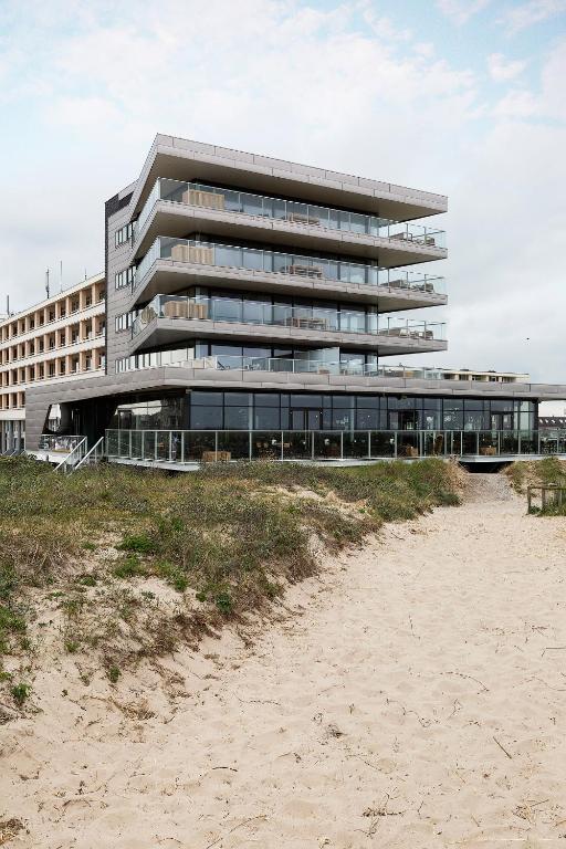 a building on the beach next to the sand at Maris Apartments in Egmond aan Zee