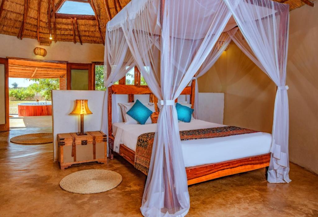 sypialnia z 2 łóżkami i łóżkiem z baldachimem w obiekcie Zaburi Beach by Serendib w mieście Mangochi