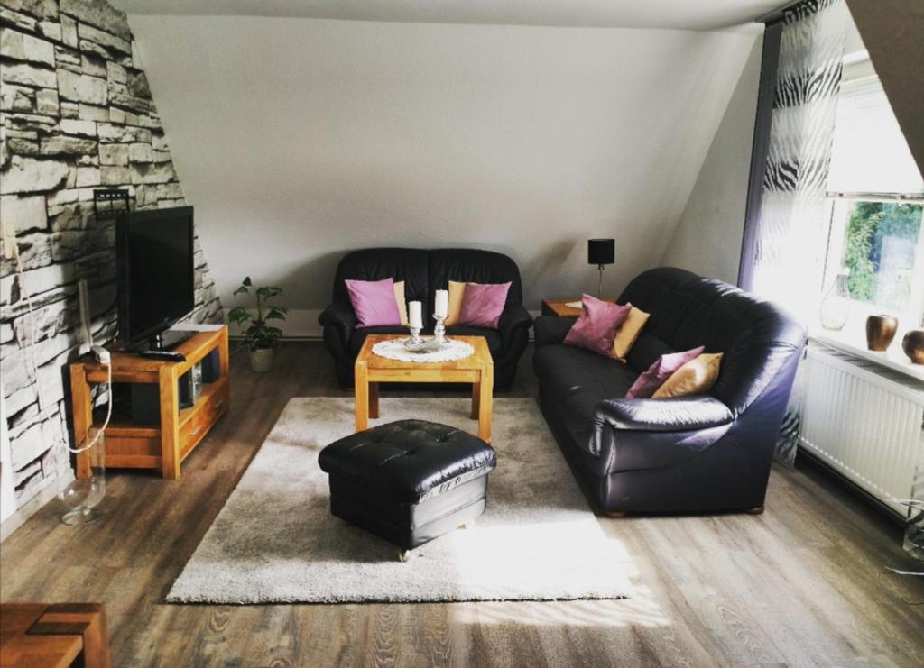 uma sala de estar com dois sofás e uma televisão em Traumnest em Großheide