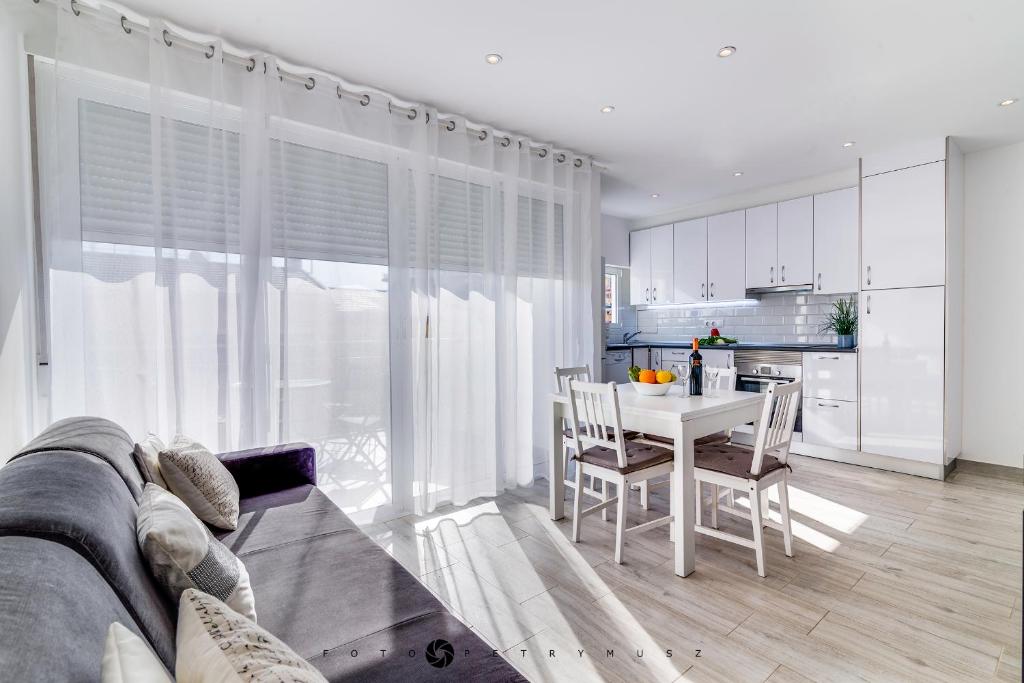 uma sala de estar com uma mesa e uma cozinha em Ravel em Alicante