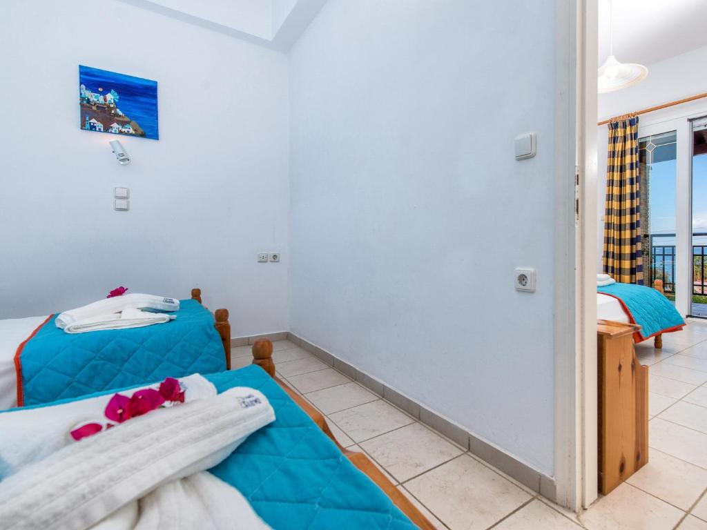 a bedroom with two beds and a balcony at Calypso Studios in Amoudi