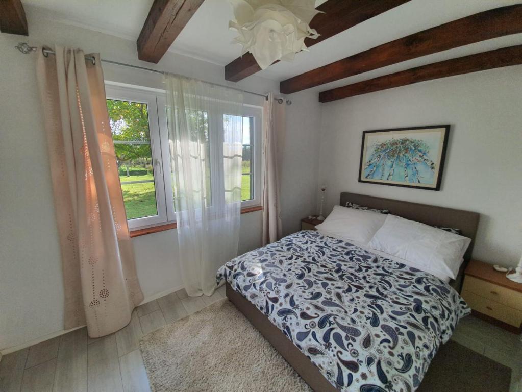 1 dormitorio con cama y ventana en Village House Flowerside, en Gospić