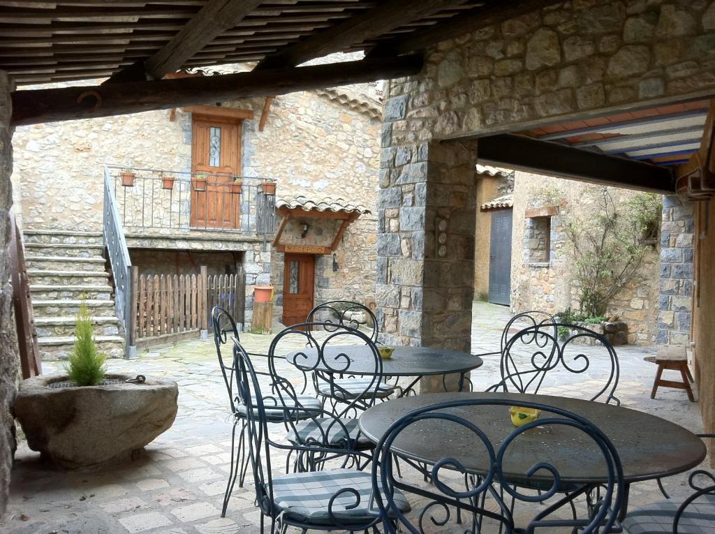 an outdoor patio with tables and chairs and a building at Cal Gabriel in Tuixen